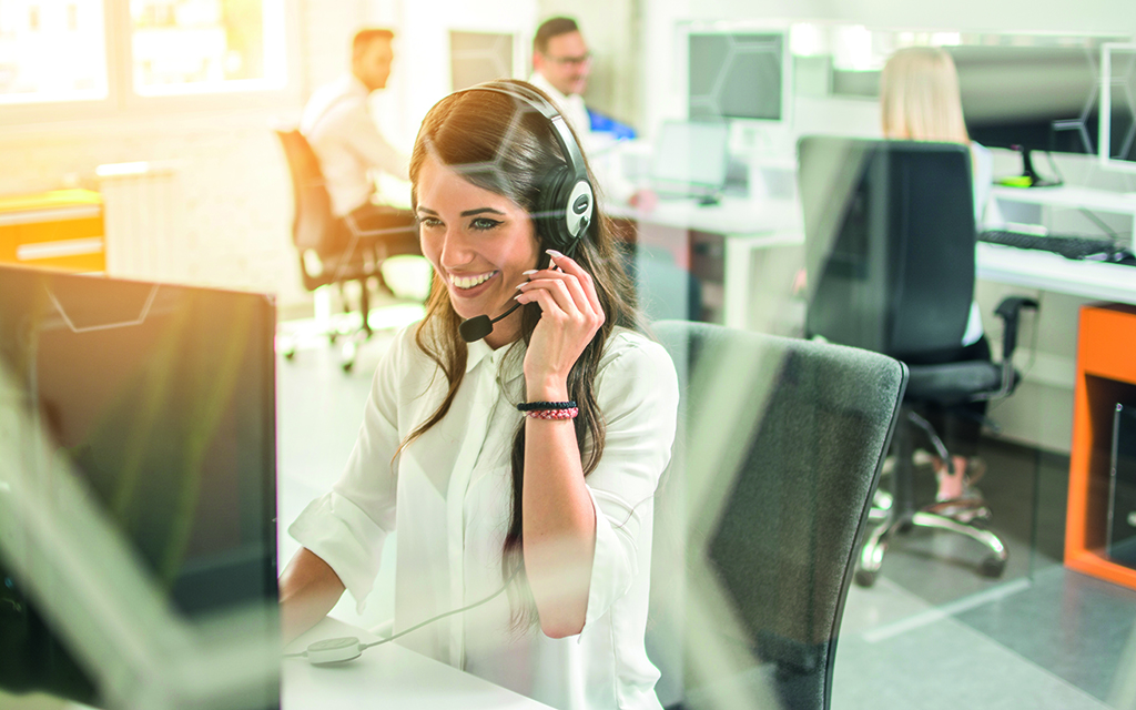 Junge Dame telefoniert am Arbeitsplatz über ein Headset Junge Dame telefoniert am Arbeitsplatz über ein Headset